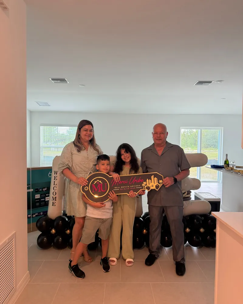 A family receiving the keys to their new home from Merci Uribe