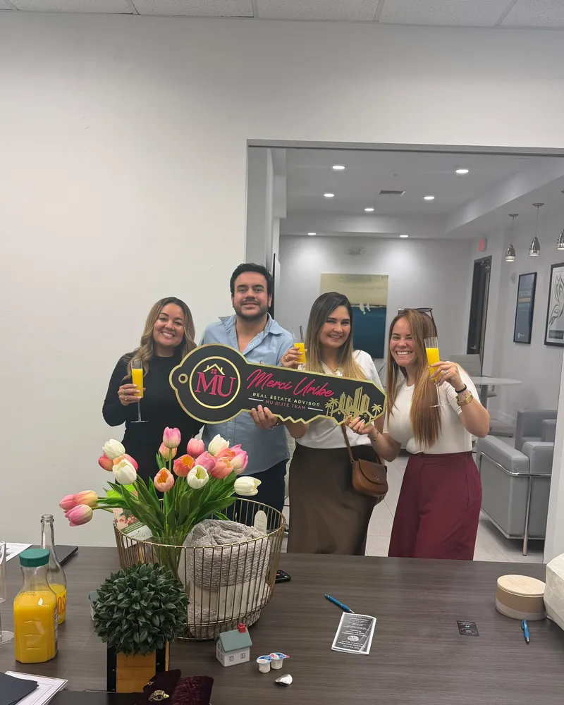 Merci Uribe and clients celebrating a closing at the office
