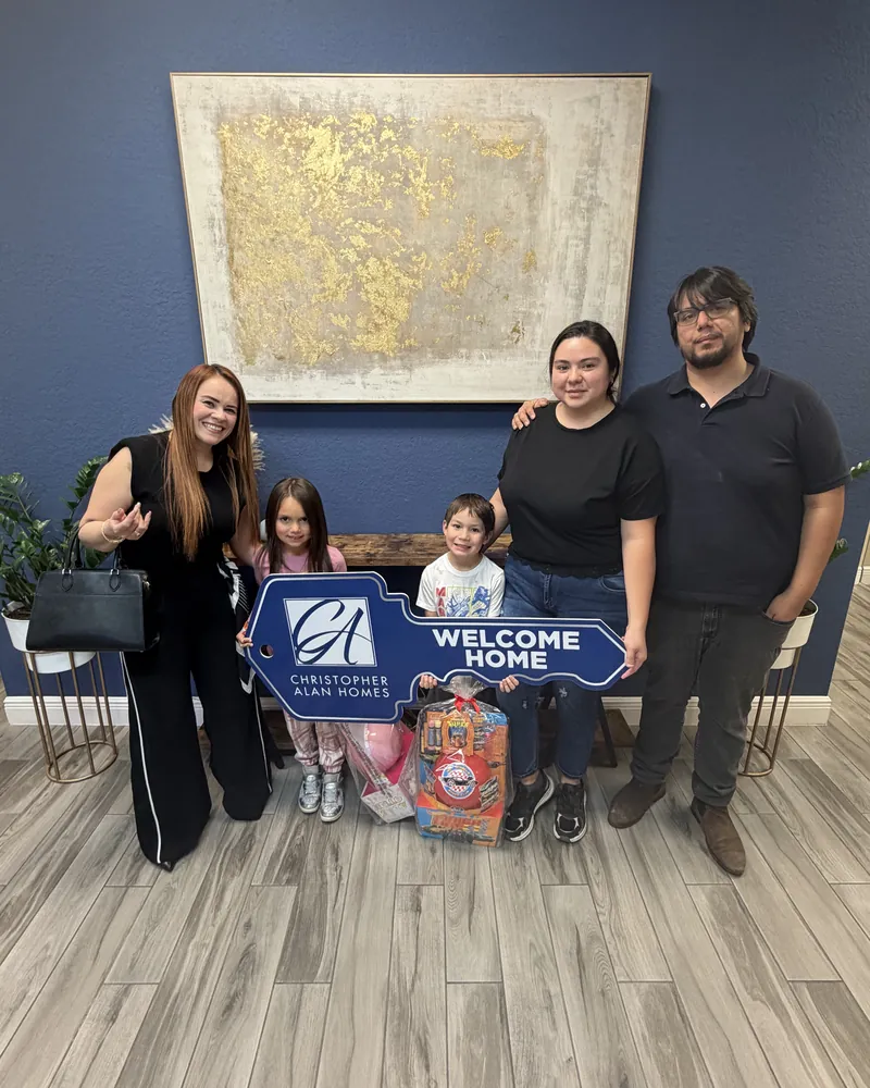 Buyers holding a Welcome Home sign with Merci Uribe
